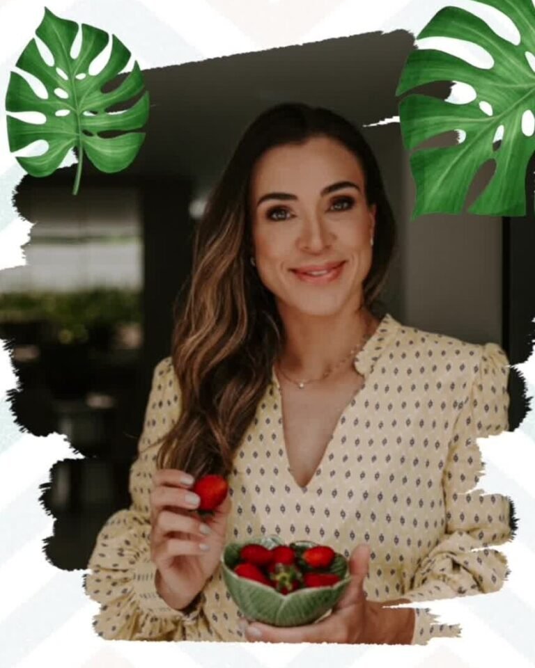 Retrato de Natalie Marques segurando uma tigela de morangos, entre folhas de costela-de-adão.